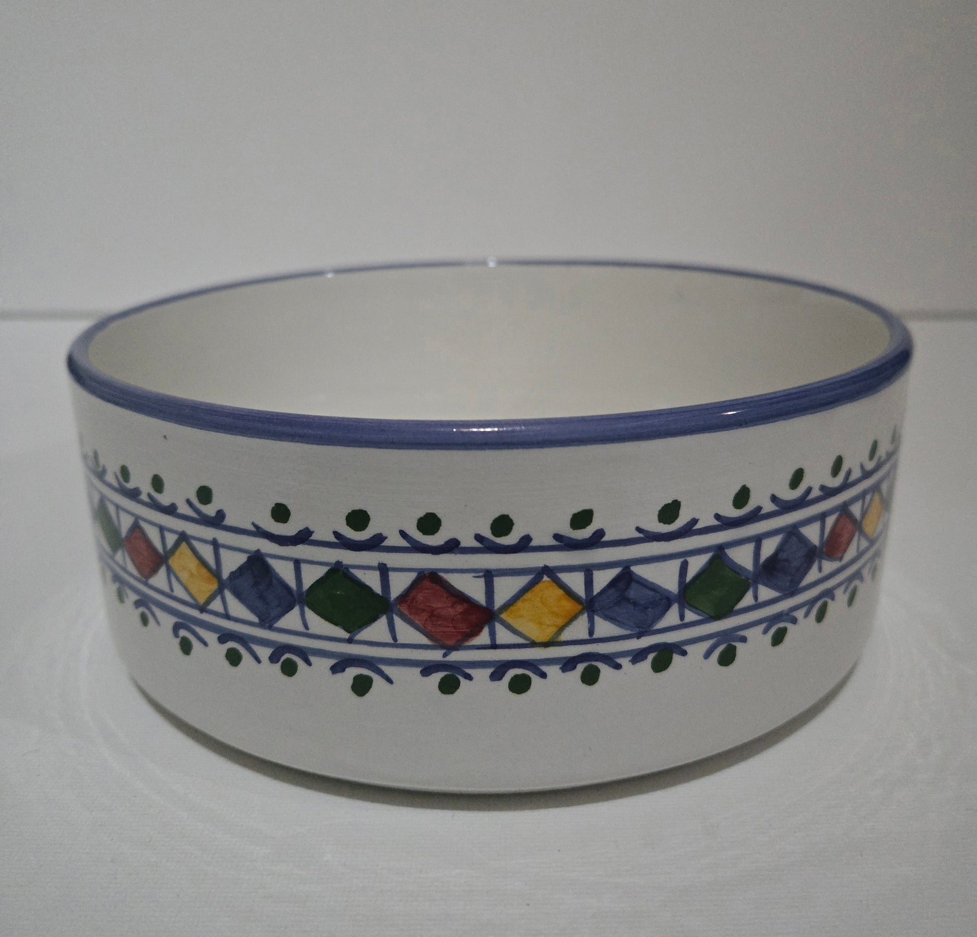 Ceramic bowl with colorful geometric pattern on a white background